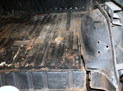 1979 Ford Bronco - The cargo area of the vehicle shows significant rust and damage to the floor and rear wheel well.