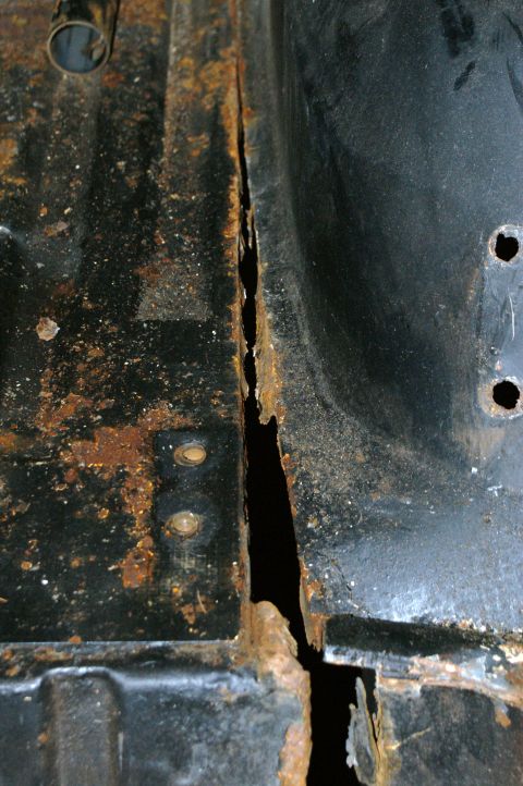 1979 Ford Bronco - Severe rust has compromised the floor pan seam, indicating significant structural damage.