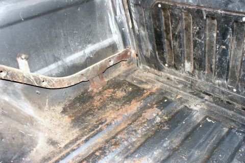 1979 Ford Bronco - The interior floor of the vehicle shows significant rust and dirt, indicating wear and potential damage.