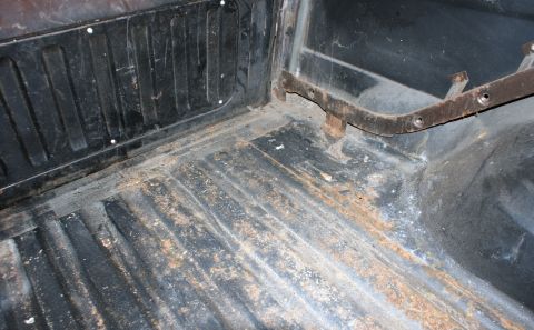 1979 Ford Bronco - The interior cargo area shows signs of wear and rust, with a ribbed floor and mounting brackets visible.