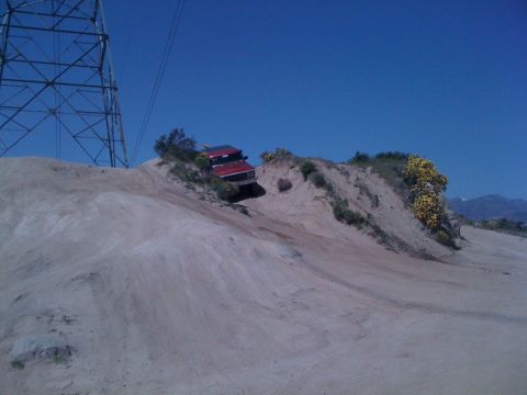 1978 Ford Bronco - This red 1978 Ford Bronco navigates a steep, sandy incline under a clear blue sky.