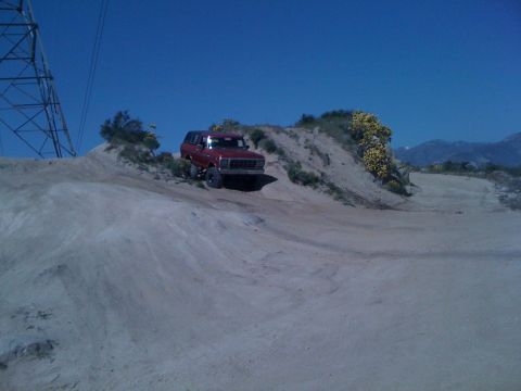 1978 Ford Bronco - 1978 Ford Bronco navigating a dirt trail under a clear blue sky.