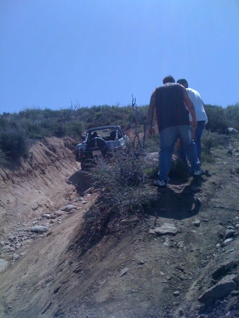 1978 Ford Bronco - A 1978 Ford Bronco navigates a steep, rocky off-road trail under a clear blue sky.