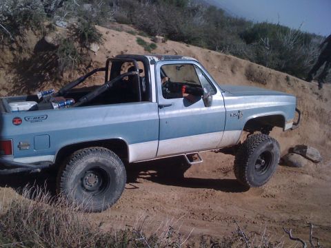 1978 Ford Bronco - This pickup truck is equipped for off-road use, large tires and a roll bar in the bed.