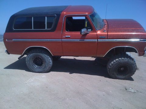 1978 Ford Bronco - Side view of a lifted 1978 Ford Bronco with off-road tires.