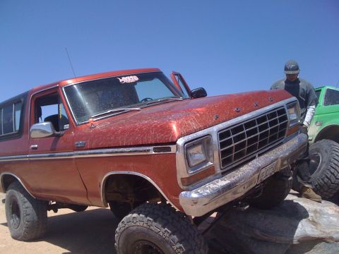 1978 Ford Bronco - This 1978 Ford Bronco is shown in a three-quarter front view, lifted and positioned on rocks, with another vehicle visible in the backgroun…