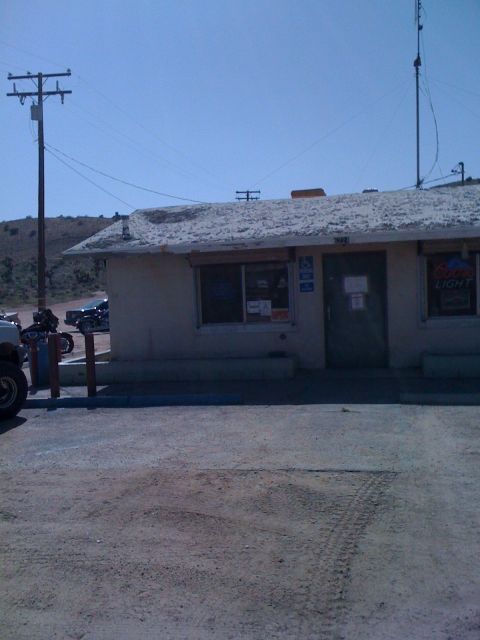1978 Ford Bronco - A building with a Coors Light sign and several vehicles parked outside under a clear sky.