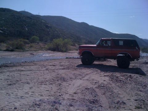 1978 Ford Bronco - This 1978 Ford Bronco is seen off-road near a stream, its large tires and classic body style.