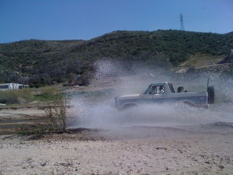 1978 Ford Bronco - A 1978 Ford Bronco kicks up a large spray of water as it drives through a shallow stream.