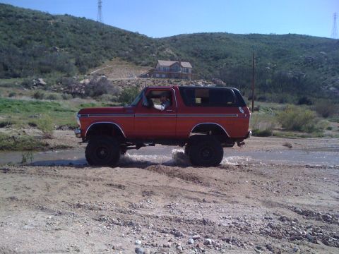 1978 Ford Bronco - This 1978 Ford Bronco is shown off-road, navigating through a water crossing in a desert-like environment.