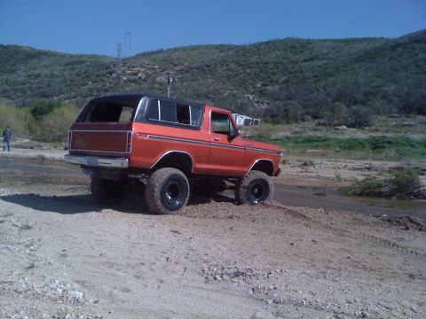 1978 Ford Bronco - 1978 Ford Bronco navigating rough terrain with a lifted suspension and off-road tires.