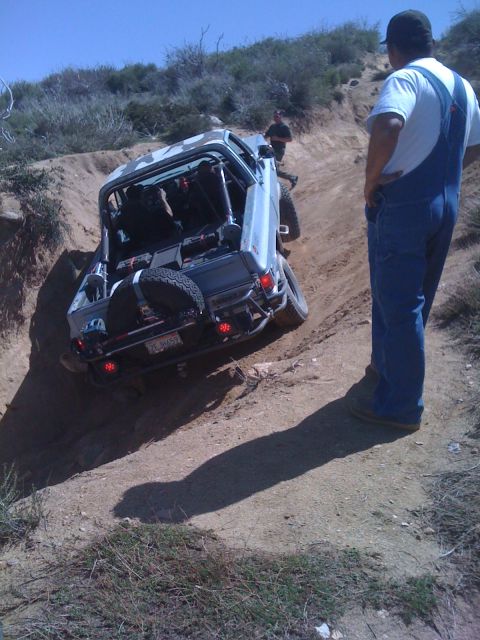 1978 Ford Bronco - Modified 1978 Ford Bronco tackles a challenging off-road climb on a sunny day.