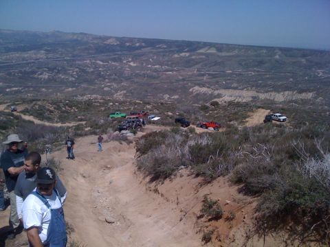1978 Ford Bronco - A group of off-road vehicles navigates a trail under a clear blue sky.