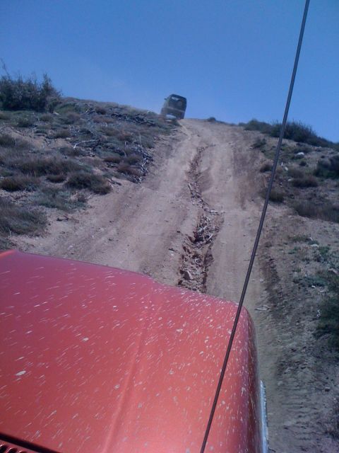 1978 Ford Bronco - Two vehicles navigate a challenging off-road trail under a clear blue sky.