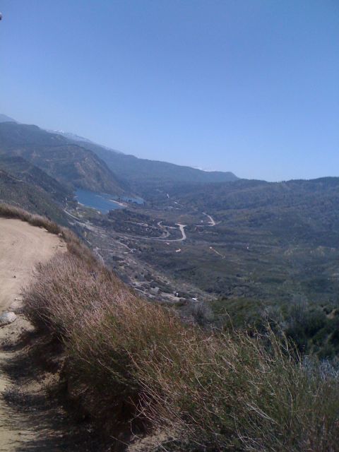 1978 Ford Bronco - A scenic view of a mountain valley with a lake and a road, captured on a clear day.