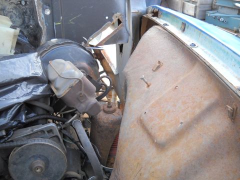 1954 Ford F-100 - Close-up view of engine bay components, including brake booster and master cylinder, with visible rust on metal panels.