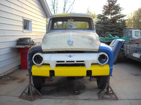 1954 Ford F-100 - This 1953 Ford F-100 pickup truck is in a state of disassembly, with its front end painted in yellow and blue.