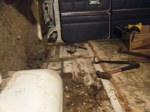 1981 Ford E350 - The interior of a van shows signs of disassembly with debris and tools on the floor.