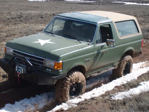 1989 Ford Bronco - This modified Ford Bronco navigates a challenging muddy and snowy terrain.