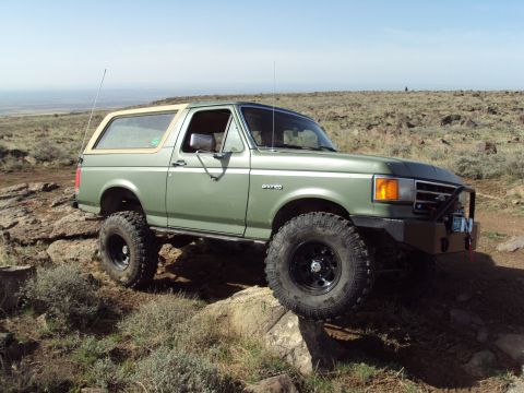 1989 Ford Bronco - This 1989 Ford Bronco navigates a rocky, off-road path under a clear sky.