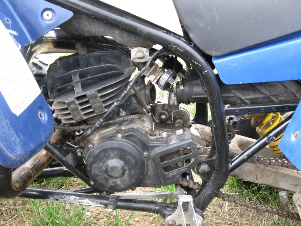 Engine of a blue dirt bike or pit bike showing cylinder, carburetor and frame