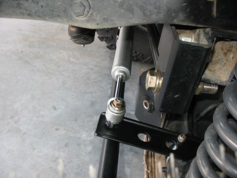 1995 Ford Bronco - Close-up view of steering stabilizer and suspension parts, likely from an off-road vehicle.
