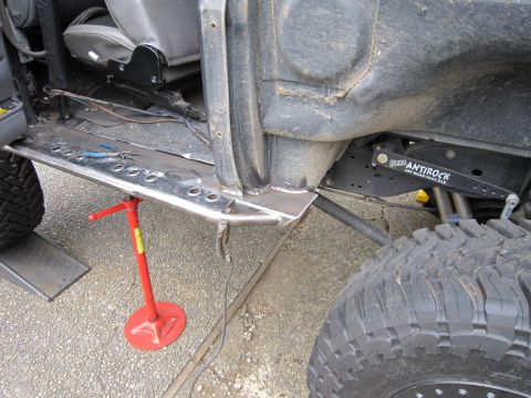 1996 Ford Bronco - Welding custom rock sliders onto a vehicle's frame, with a jack and suspension components visible.
