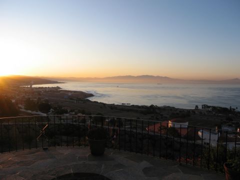 1986 Ford Bronco - A scenic view of the coast at sunset, with the sun low on the horizon.