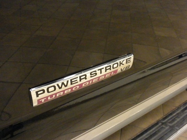 Close-up of a Power Stroke Turbo Diesel V8 badge on a dark vehicle body
