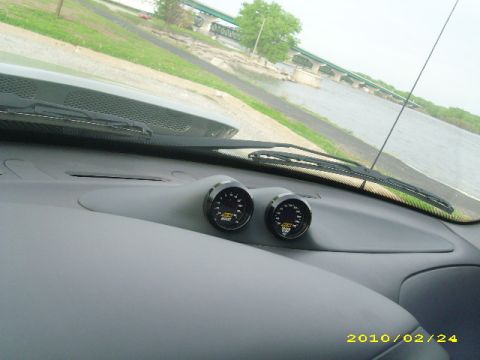 2007 Ford Mustang - Interior view of a dashboard with aftermarket gauges and a view of a bridge over water.