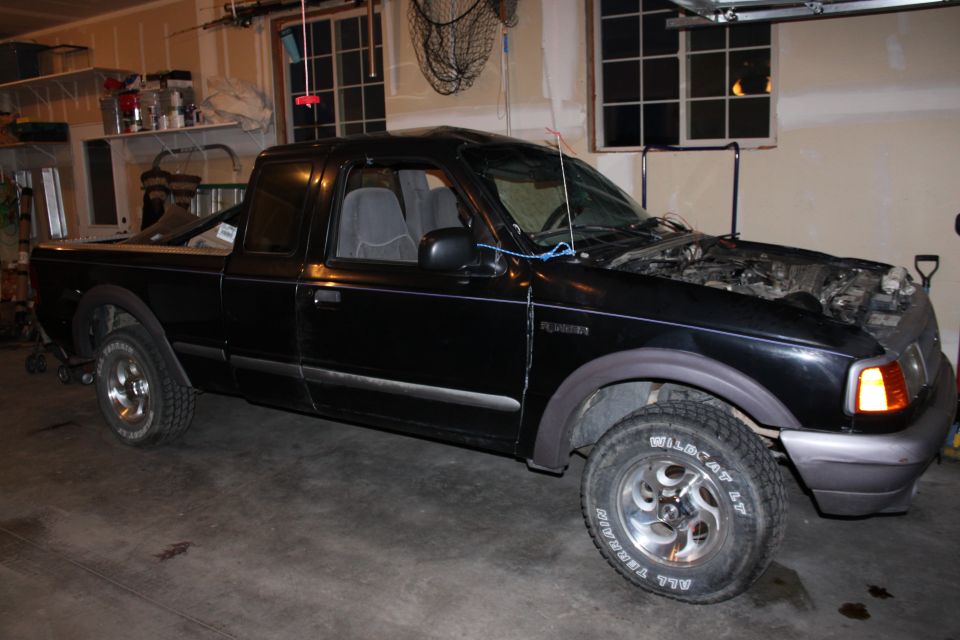 Black 1997 Ford Ranger pickup truck with hood open, parked in a garage