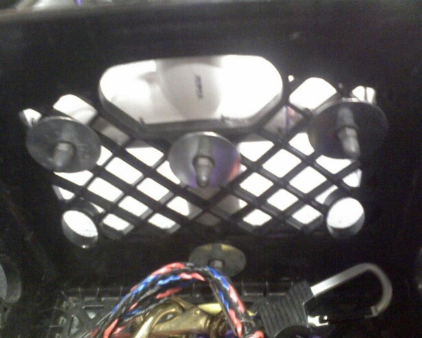 Interior view of a car part with a diamond grille and visible wires