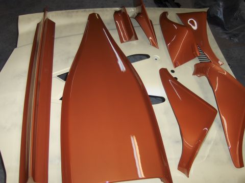 1980 Chevrolet Camaro - Various orange car body panels are arranged on a white surface, with a watermark at the bottom right.