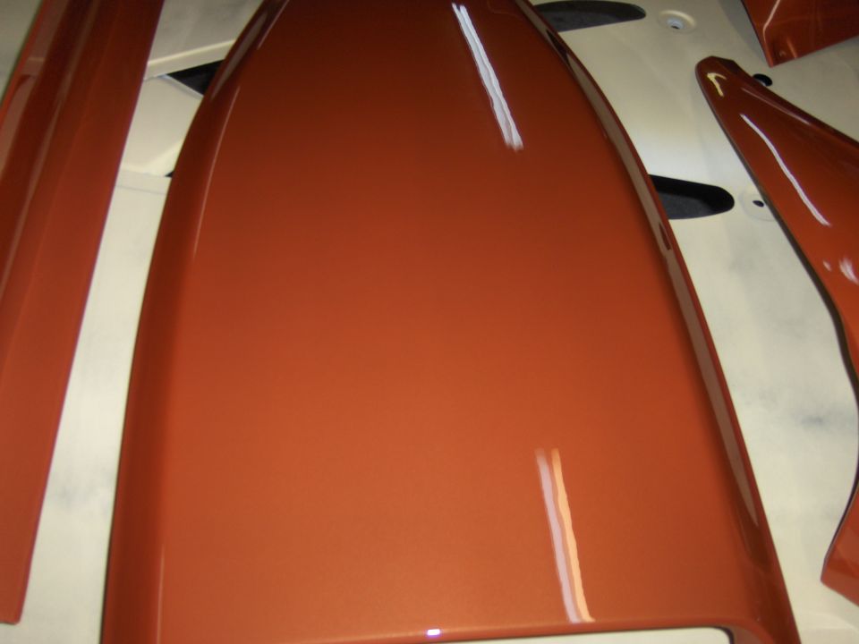 Orange car hood and fender pieces, possibly freshly painted