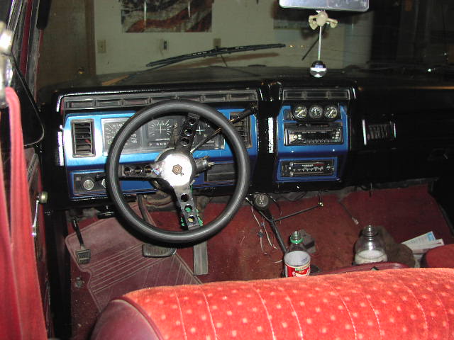 Truck dash with blue trim, three-spoke wheel, gauge pod and two stereo decks