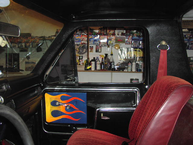 Ford truck interior with red bucket seat and custom flame-painted door panel insert