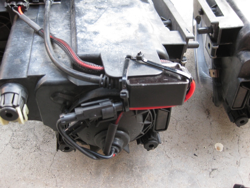 close-up of a car headlight assembly with wiring