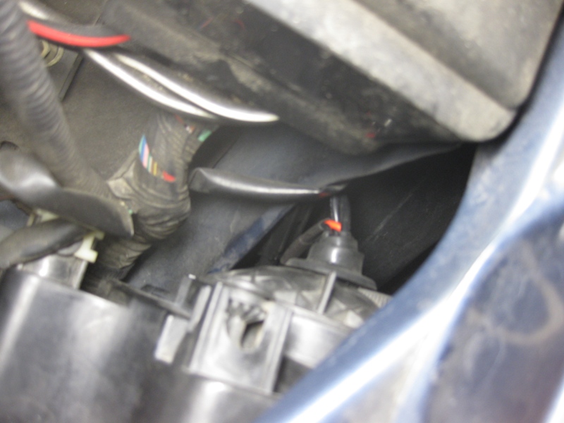 Close-up of automotive wiring and headlight assembly with Supermotors.net logo