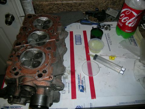1995 Ford Probe - A disassembled engine cylinder head sits on a table with various tools and supplies.
