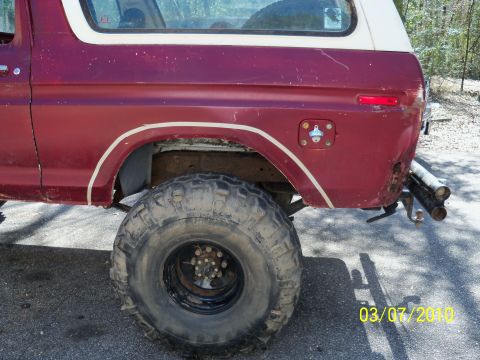 1978 Ford Bronco - Rear view of a red 1978 Ford Bronco showing its quarter panel and large tire.