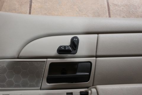 2007 Ford Crown Victoria - Close-up of a car's interior door panel, showing the power seat adjustment controls and a speaker grille.