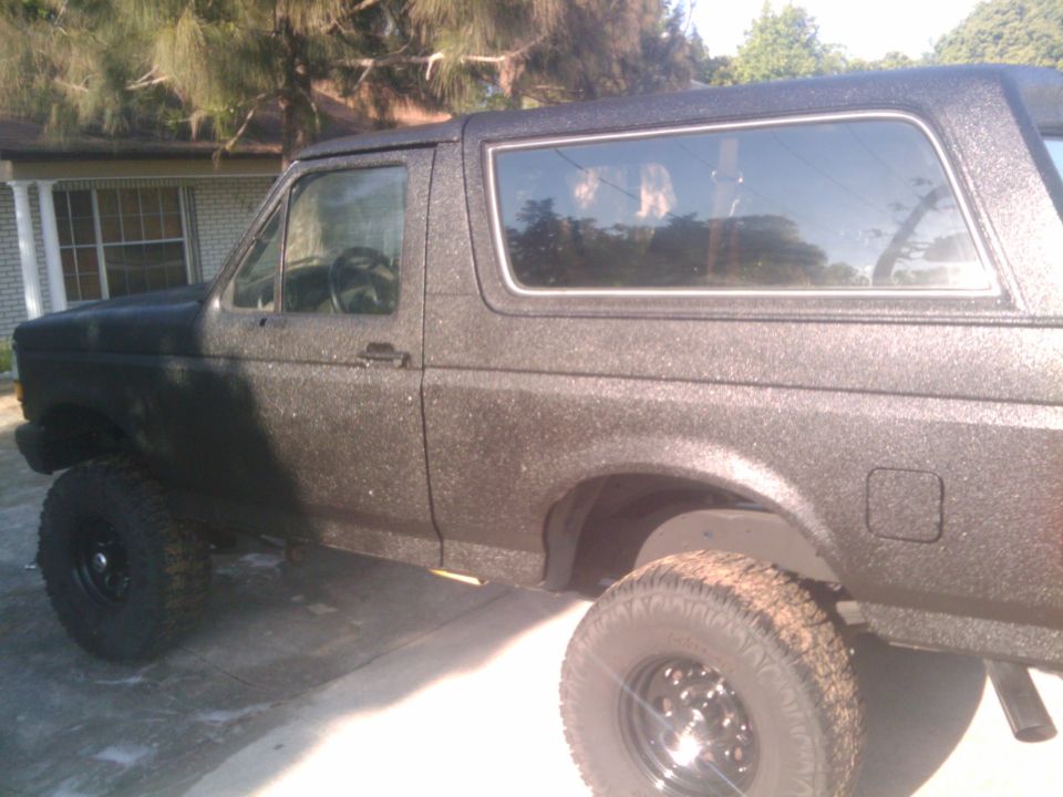 1992 Ford Bronco with textured black paint, lifted suspension, and aftermarket wheels
