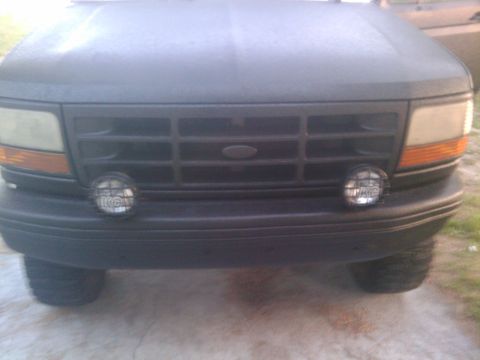 1993 Ford Bronco - Front view of a black Ford Bronco with KC lights mounted on the bumper.