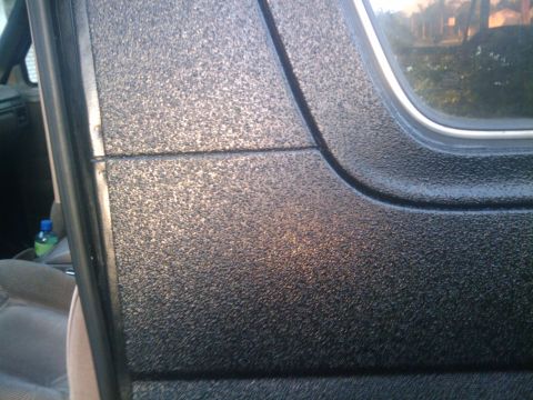 1993 Ford Bronco - Close view of the textured exterior paint on a vehicle's door panel.