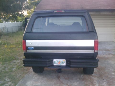 1993 Ford Bronco - Rear view of a black Ford Bronco with a silver stripe on the tailgate and a Florida license plate.