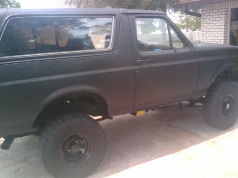 1993 Ford Bronco - A side profile of a black 1993 Ford Bronco, likely modified with a textured paint job.
