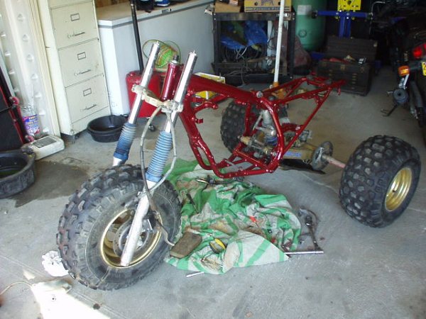Red frame three-wheeler with front suspension and large tires