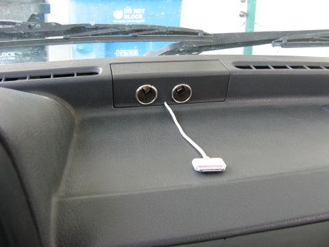 1991 Ford Festiva - The dashboard interior shows dual cigarette lighter sockets, with a white cable connected to one of them.