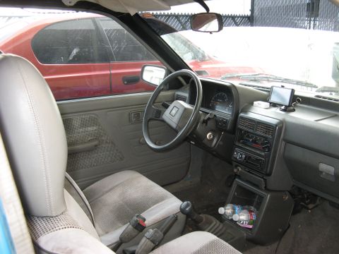 1991 Ford Festiva - The interior of a car is shown, with a second vehicle visible outside the driver's side window.