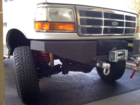 1996 Ford Bronco - Front view of a white Ford Bronco with a chrome grille and a black aftermarket bumper equipped with a winch.